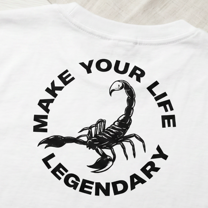 White t-shirt with black scorpion graphic and text on a light background